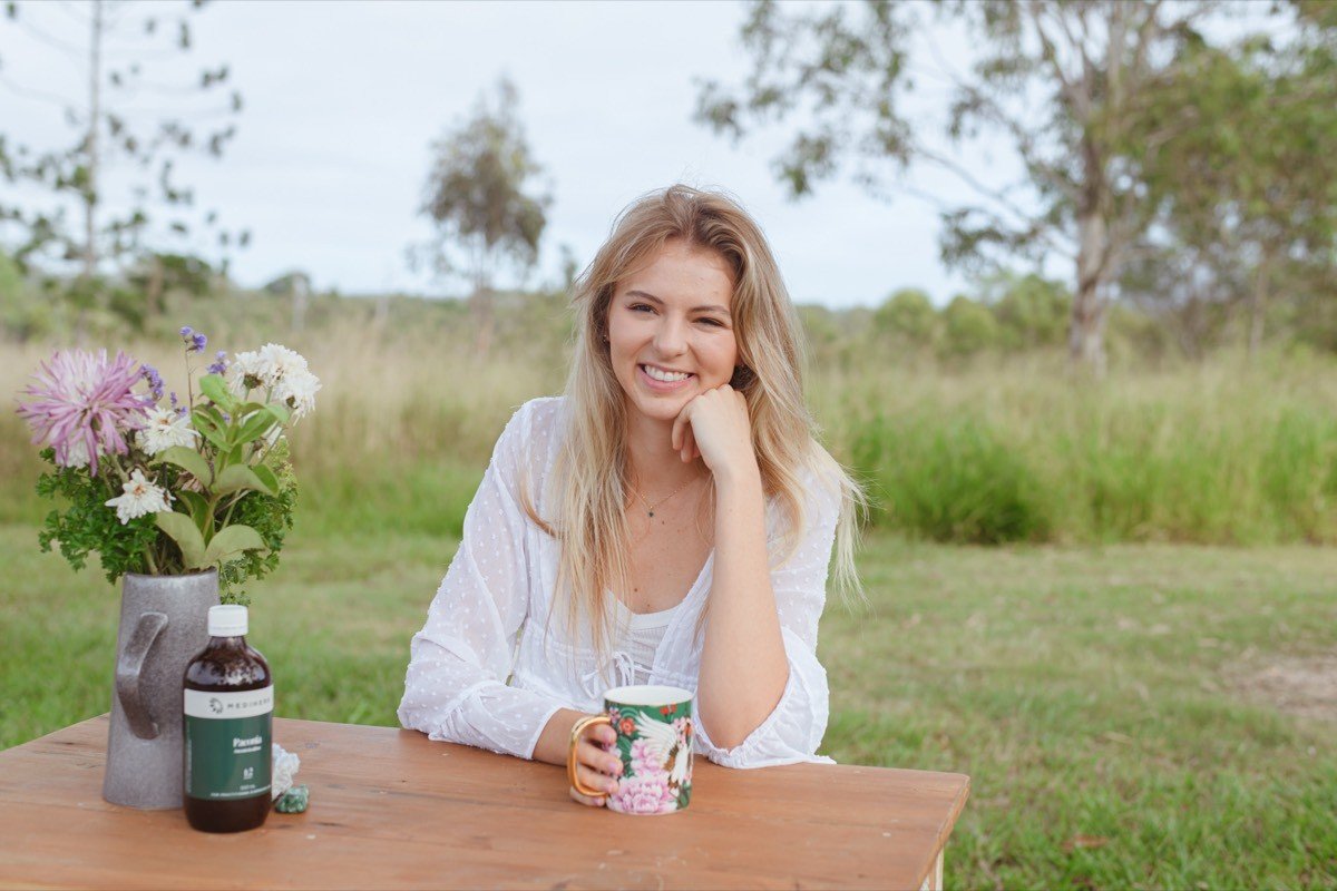 Amy Angus Brisbane naturopath outdoors with herbal medicine and flowers